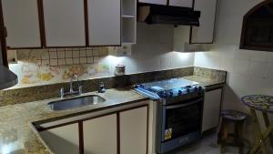 uma cozinha com um lavatório e um fogão em Arraial do Cabo - Suite luxo em Arraial do Cabo