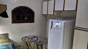 uma cozinha com um frigorífico branco em Arraial do Cabo - Suite luxo em Arraial do Cabo
