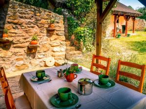 a table with green cups and plates on it at Wild Boar Cottage - Romantic getaway in Badacsonytomaj