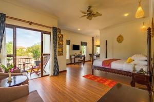 um quarto com uma cama e uma sala de estar em Beyond Yangon Inn em Siem Reap
