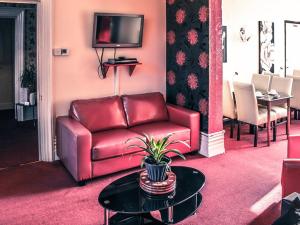 ベッドフォードにあるTennyson House Hotelのリビングルーム(赤い革張りのソファ、テーブル付)