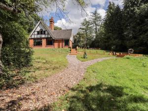 una casa en una colina con un camino de grava delante en Baldwins Hill Cottage, en Loughton