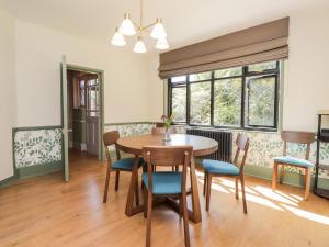 a dining room with a table and chairs at Baldwins Hill Cottage in Loughton