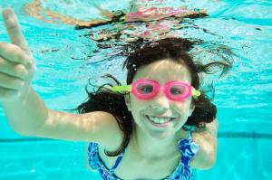 a young girl in a swimming pool wearing goggles at Hyatt Regency Dallas in Dallas