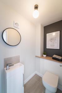 a bathroom with a white toilet and a mirror at River Retreat Apartment Exeter - River Views & Parking in Exeter