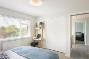 een slaapkamer met een bed en een groot raam bij River Retreat Apartment Exeter - River Views & Parking in Exeter