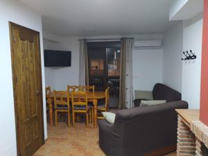 a living room with a table and chairs and a couch at Alojamiento Fuentes in Arroyo Frio