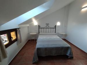 a bedroom with a bed and two tables in it at Alojamiento Fuentes in Arroyo Frio +13 photos
