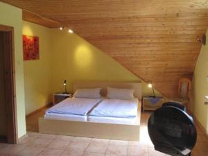 1 dormitorio con 1 cama con techo de madera en Landhotel Grafenfels, en Lemberg