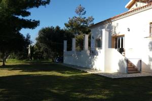 uma casa branca com um quintal ao lado em Villa Dionisia, Relaxation with Jacuzzi Retreat em Svoronata