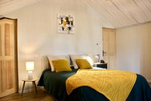 una camera con un letto con due cuscini gialli di Le Clos Vitis a Violès