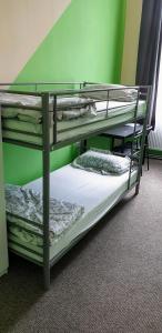2 łóżka piętrowe w pokoju z zieloną ścianą w obiekcie Mir hostel w Berlinie