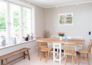 a dining room with a wooden table and chairs at Villa Fryksta in Kil