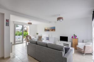 a living room with a couch and a dining room at Flochouët - Maison avec jardin - Trélivan proche Dinan in Trélivan