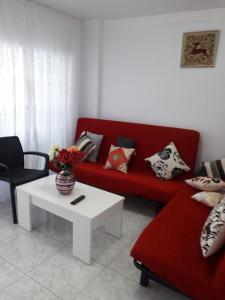 a living room with a red couch and a coffee table at Apartamento Deluxe Yumbo in Playa del Ingles