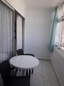 een witte tafel en stoelen in een kamer met een raam bij Apartamento Deluxe Yumbo in Playa del Inglés