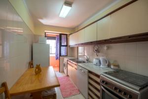 Una pequeña cocina con estufa y refrigerador. en Apartamento São Pedro do Mar, en Quarteira