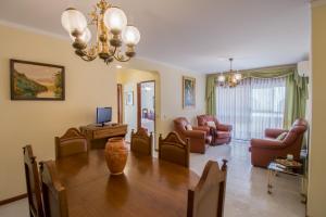 Un comedor con una mesa y una sala de estar. en Apartamento São Pedro do Mar, en Quarteira