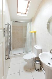 a bathroom with a toilet, sink, and bathtub at 272&294 Franciscan Road Rooms&Studios by EveryWhere to Sleep London in London