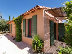 a small house with green shutters on it at Gîte du salagou in Octon