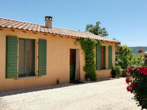 ein Haus mit grünen Fensterläden und Rosen in der Unterkunft Gîte du salagou in Octon + 28 Fotos