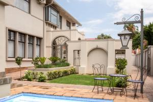 a villa with a swimming pool and a house at Adato Guesthouse in Potchefstroom