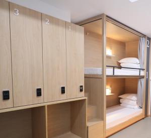 Pokój z łóżkiem piętrowym i drewnianymi szafkami w obiekcie 杭州武林国际城市营地 w mieście Hangzhou