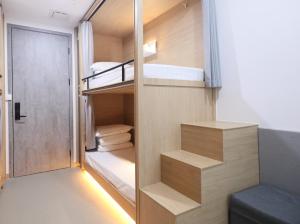 Cette petite chambre comprend des lits superposés et une porte. dans l'établissement 杭州武林国际城市营地, à Hangzhou