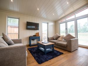 a living room with two couches and a table at Wren Lodge in Skipton