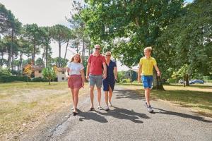 um grupo de pessoas andando por uma estrada de terra em Résidence Château de Salles em Salles