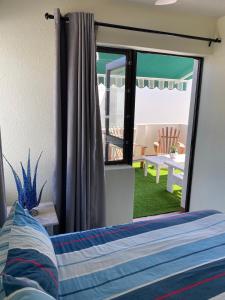 a bedroom with a bed and a view of a patio at 11 Arrowood in Plettenberg Bay