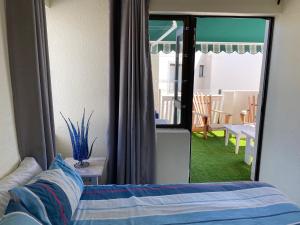 a bedroom with a bed and a view of a patio at 11 Arrowood in Plettenberg Bay