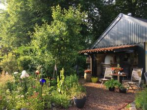 a garden with a house with a table and chairs at T’ Hogeland Ainrom in Eenrum