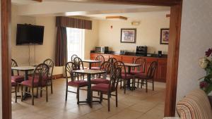 Un comedor con mesas y sillas y una cocina. en Scotland Neck Inn, en Scotland Neck