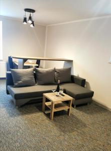 uma sala de estar com um sofá e uma mesa em LOFT Aparthotel em Zlocieniec