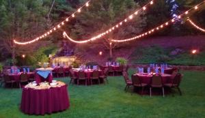eine Gruppe von Tischen und Stühlen in einem Hof mit Lichtern in der Unterkunft The Lodge at Flat Rock in Upward