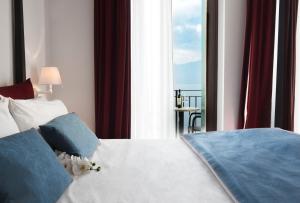 a bedroom with a bed with a view of the ocean at Hotel Del Porto in Torri del Benaco