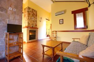 sala de estar con sofá y chimenea en Aventura & Relax Cabañas Peña la Higuera en Villalba de la Sierra