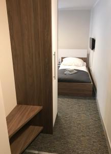een kleine slaapkamer met een bed en een kast bij LOFT Aparthotel in Złocieniec