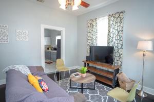 a living room with a purple couch and a flat screen tv at Remodeled Historic 2BR 1BA House Near Downtown in San Antonio
