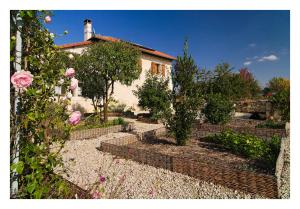 una casa con un jardín con árboles y rosas en Au Pichet en Saint-Orens