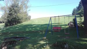 un parque infantil con un columpio en un patio en Penzion Severka, en Rokytnice v Orlických horách