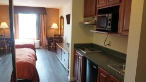 Una habitación de hotel con cocina y dormitorio. en Scotland Neck Inn, en Scotland Neck