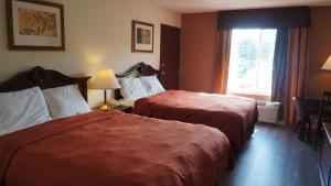 Una habitación de hotel con dos camas y una ventana. en Scotland Neck Inn, en Scotland Neck 31 fotos más