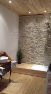 a bathroom with a stone wall and a bath tub at Château de Nettancourt in Nettancourt
