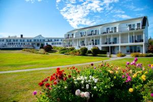 a large white building with flowers in the yard at Newagen Seaside Inn in Southport