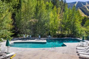 a swimming pool with chairs and a mountain at Prospector 205 in Ketchum