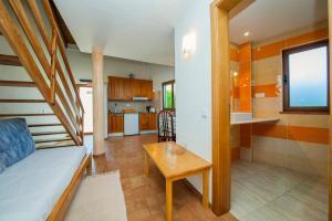 a living room with a couch and a table and a kitchen at H - Montes de Praias GuestHouse in Aljezur