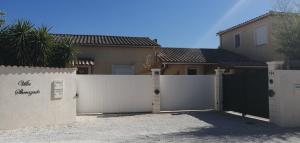 a white fence in front of a house at Maison F2, neuve au calme avec jardinet in La Crau
