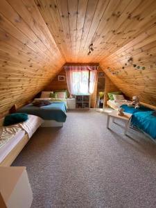 a large room with two beds and a wooden ceiling at Grey House in Dębki